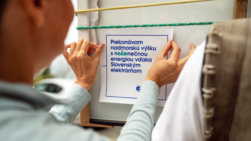 Ľudia umiestňujú označenie „Prekonávam nadmorskú výšku s nekonečnou energiou vďaka Slovenským elektrárňam“ – projekt ekologizácie vysokohorských chát.